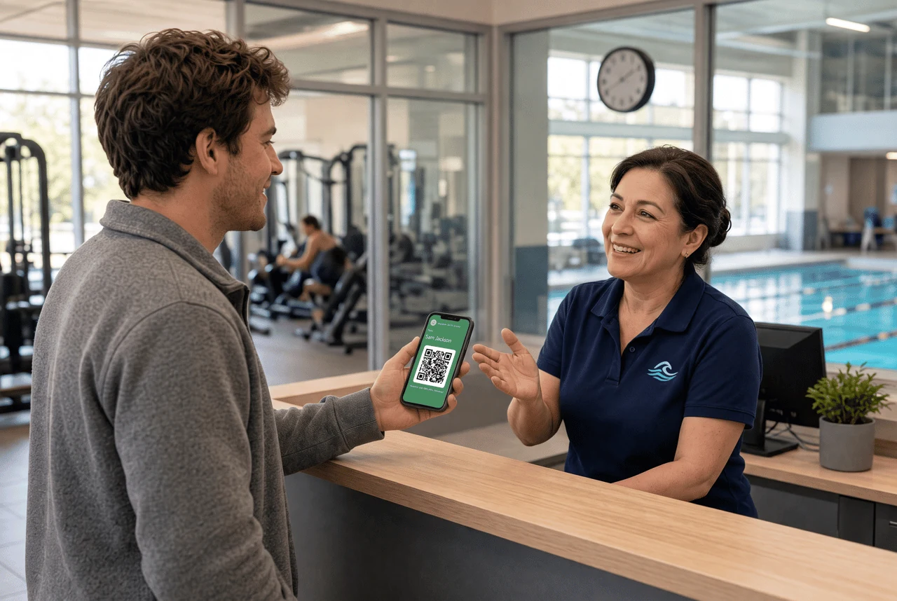 Man shows a QR-code pass on his phone to a smiling staff member at a pool reception desk.